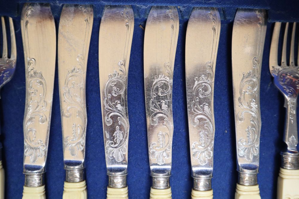 A Victorian set of twelve plated and engraved fish knives and forks, with carved ivory handles, mahogany cased